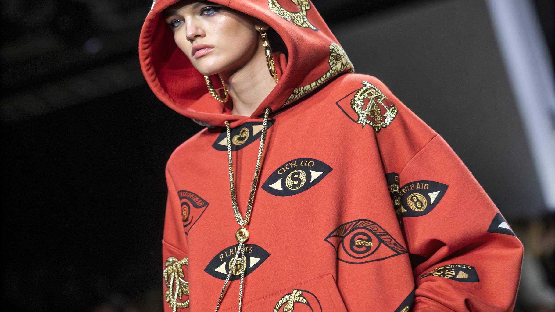 Model wearing an oversized Vetements hoodie with large logos and graphic prints, emphasizing the bold, baggy silhouette and unique style compared to a traditional hoodie.